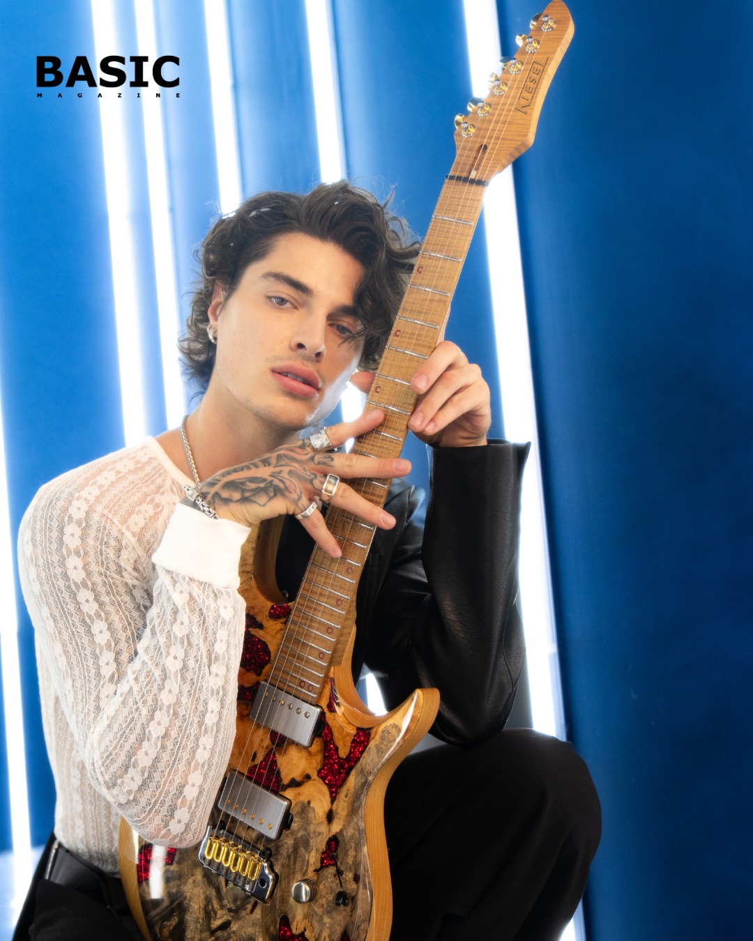 Jon Dretto holding his guitar in a blue-lit editorial portrait for BASIC Magazine