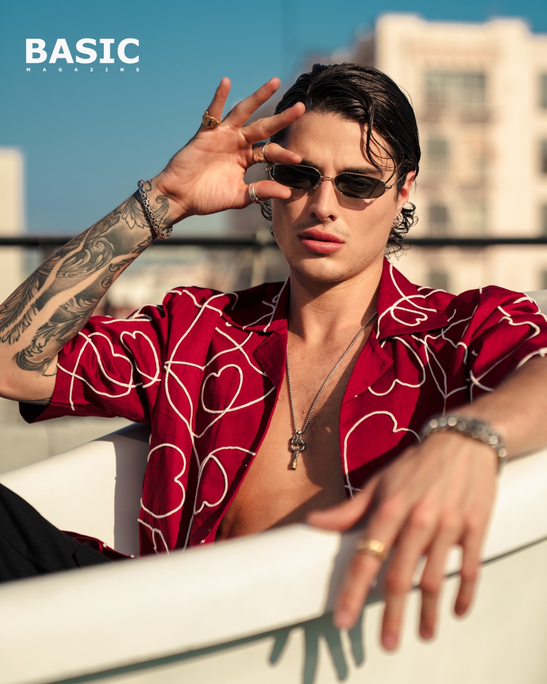 Jon Dretto in a red shirt photographed on a rooftop for BASIC Magazine